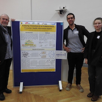 Three presenters standing next to a poster titled 'Analyzing Interactions in an Evidence-based Consumer Health Information System,' presented as part of the A+CHIS results at the MIND & BRAIN conference.