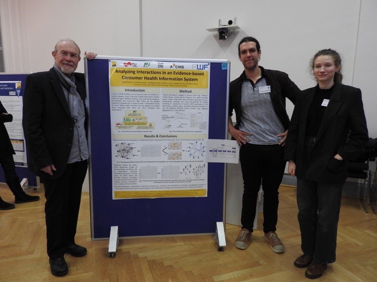 Three presenters standing next to a poster titled 'Analyzing Interactions in an Evidence-based Consumer Health Information System,' presented as part of the A+CHIS results at the MIND & BRAIN conference.